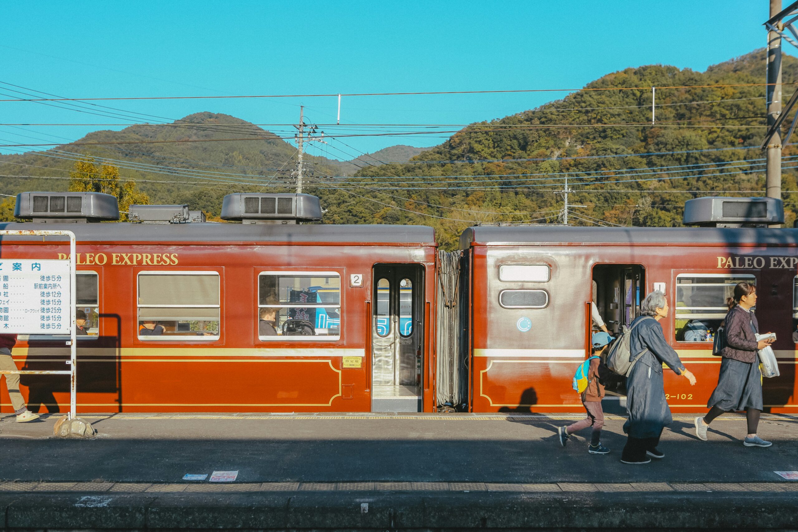 A group of people walking next to a train